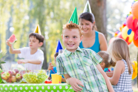Happy boy with party hat on a party in the garden